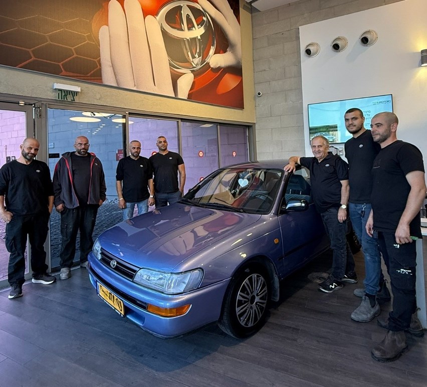 צוות המוסך לצד המכוניות המשופצת